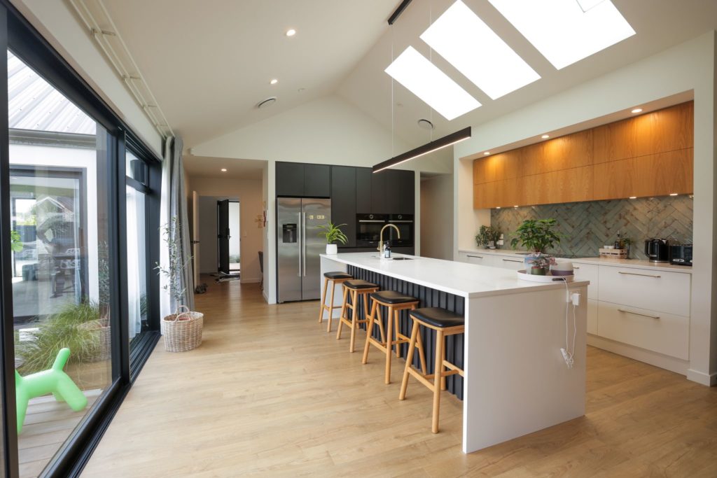 Modern kitchen featuring a breakfast bar and skylights. Built by R&B Build New Zealand