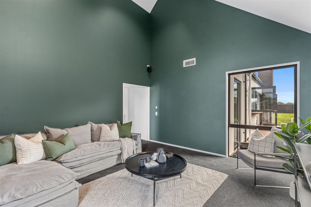 Large living room with green feature walls and high ceilings in Christchurch. Built by R&B Build