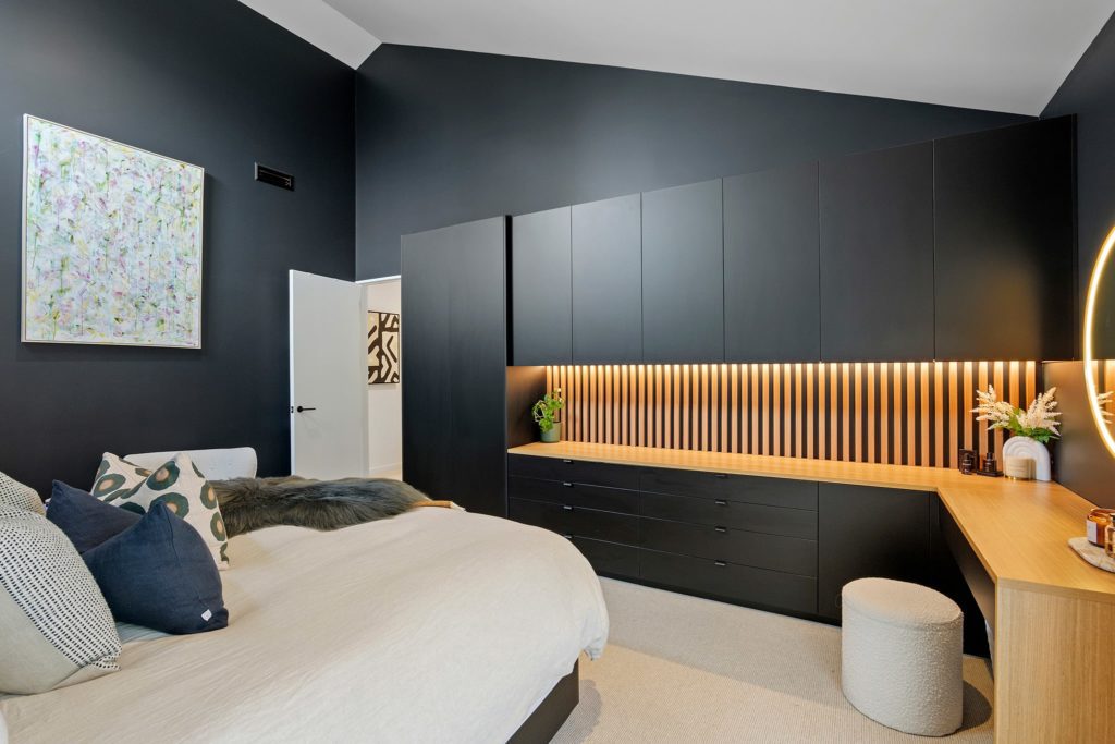 Modern bedroom featuring black feature walls and inbuilt vanity. Built by R&B Build