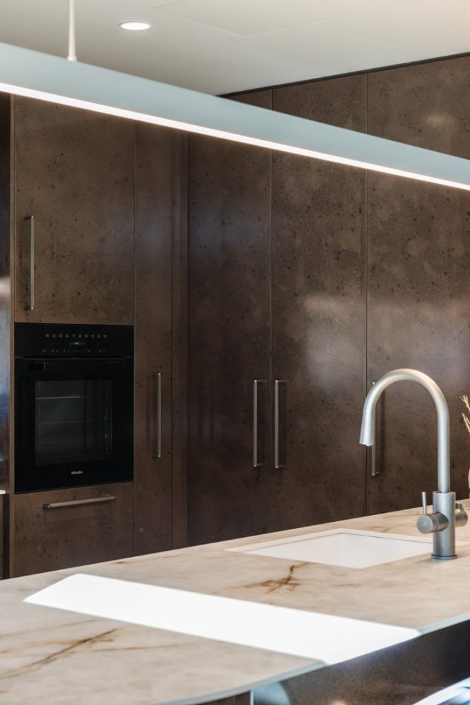 Architectural designed kitchen featuring interesting brown cabinetry. Designed and Built by R&B Build